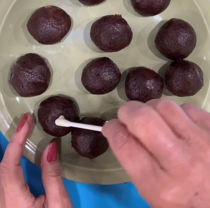 Dip sticks into white chocolate and press into cake balls.